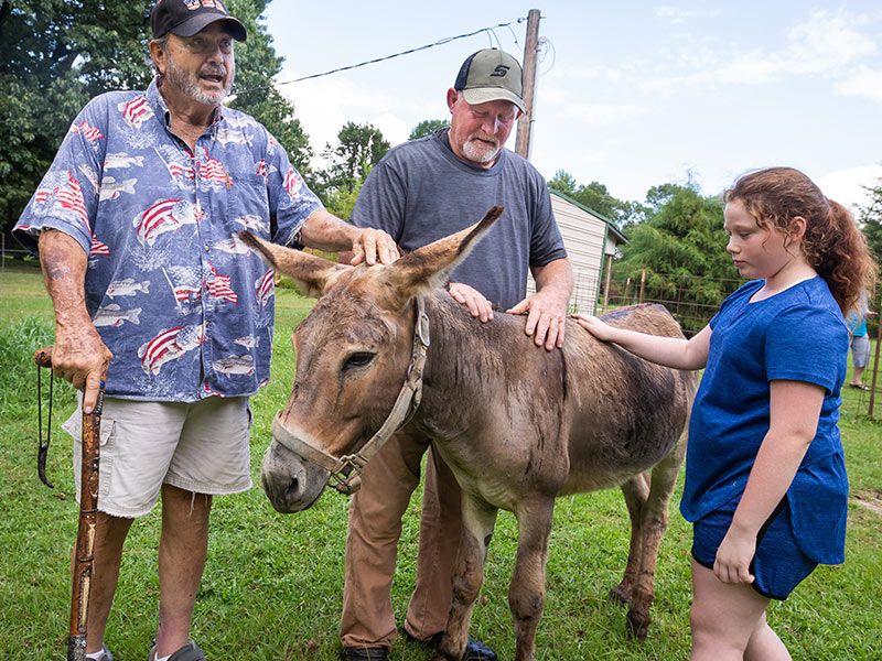 From left, Eupora residents Ray Gustafson, his neighbor Dale Wilson, Ray's granddaughter Haley Blount, and Bobo the donkey.