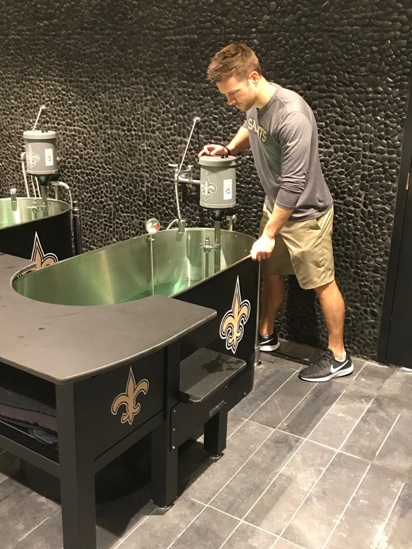 Cody Pannell prepares a whirlpool bath for use by New Orleans Saints players following practice.