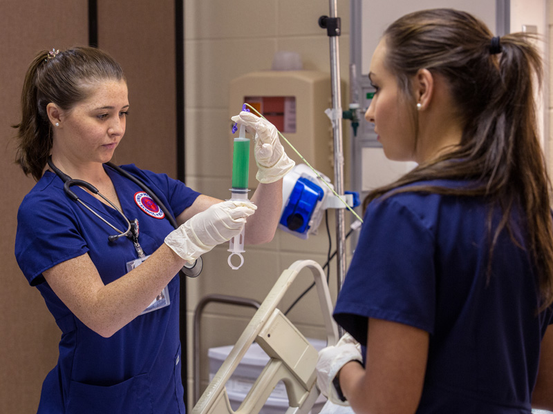Reagan Patrick, left, and Lauren Nuckles, both juniors in the School of Nursing, measure gastric residual volume on a simulation patient who has a nasogastric tube.