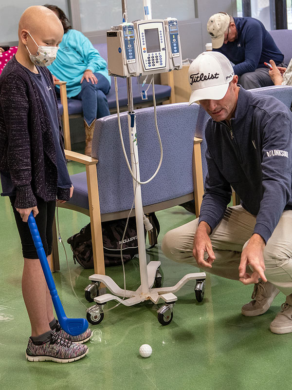 Professional golfer Nicholas Lindheim teaches Batson Children's Hospital patient Cameron Stewart of New Augusta how to putt.