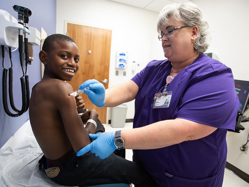 Jarques Jones, 12, of Magee is a trooper as he receives an HPV vaccine from Pam Whittington, L.P.N.