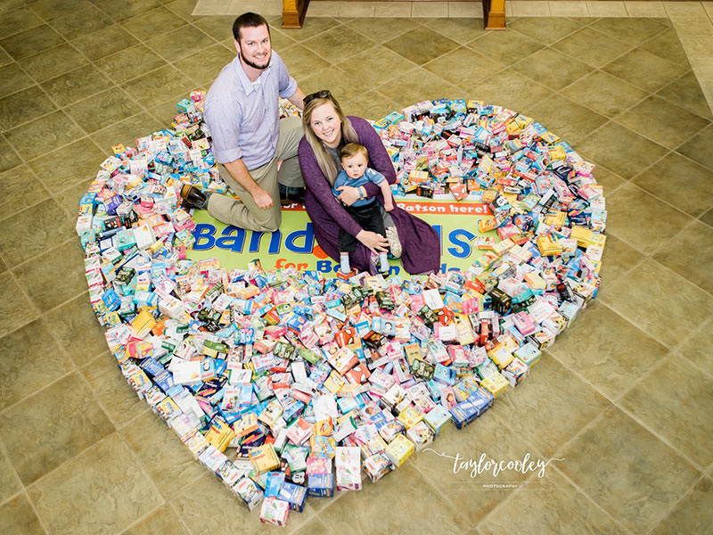 Mark and Paige Welch and their son, Jack, show some of the many bandages collected through their Band-Aids for Batson campaign. (Photo courtesy of Taylor Cooley Photography.)