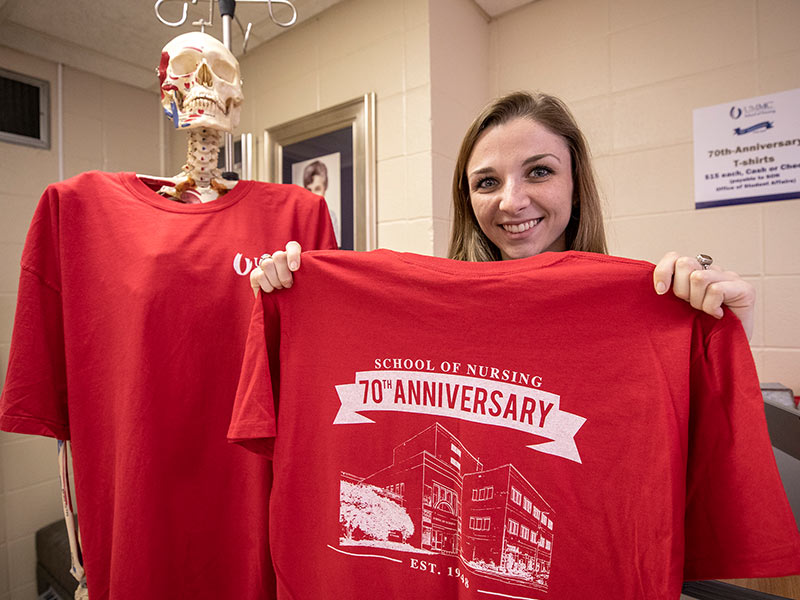 Carson Williams, senior and student ambassador in the School of Nursing, shows off the anniversary T-shirt.