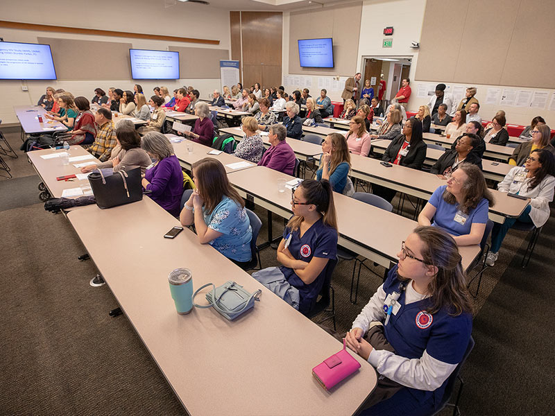 Attendees of the School of Nursing's 70th anniversary listen to remarks from Medical Center Vice Chancellor LouAnn Woodward, former Vice Chancellor and Dean of the School of Medicine James Keeton and Dean of the School of Nursing Kim Hoover.