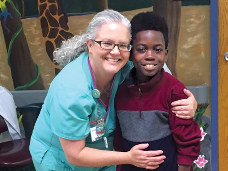 Stennis Miller gets a hug from April Wogoman, a nurse at Children's Hospital.