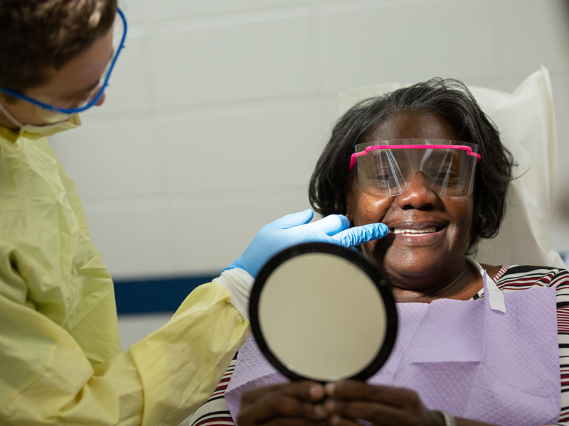 Patricia Hubbard, who was one of 22 patients to receive a free set of dentures during Dental Mission Week, checks out her new smile.