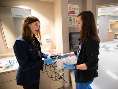 Registered nurses Allen Spencer, left, and Rosalie Powell confer following the transfer of a patient from the SICU to a room in the adult hospital.