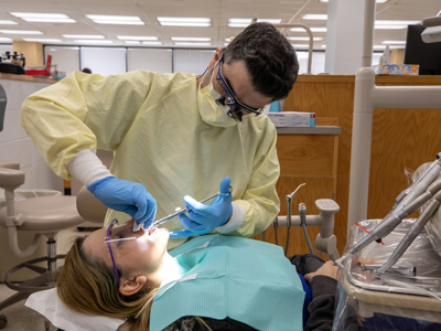 Fourth year dental student Alper Coban applies a crown to patient and wife Seval Ozkan.