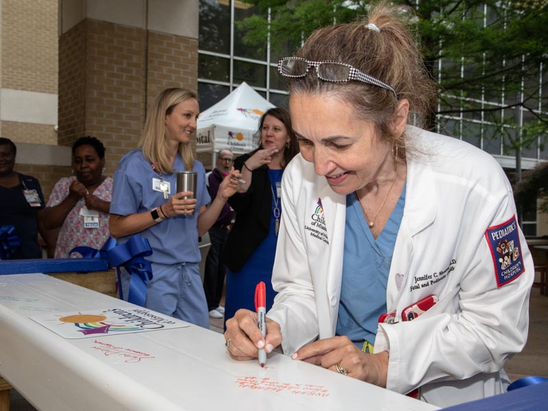 Fetal cardiologist Dr. Jennifer Shores signs the beam that will go to the top of the seven-story pediatric expansion.