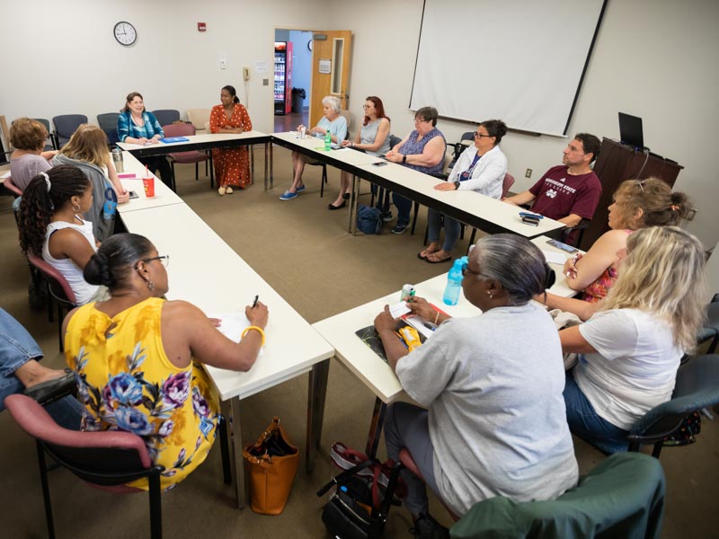 Sue Ann Meng, back left, social worker, and Dr. Liana Singh, back right, geriatrics fellow, lead the Medical Center's Alzheimer's caregiver support group during its July 2019 meeting.