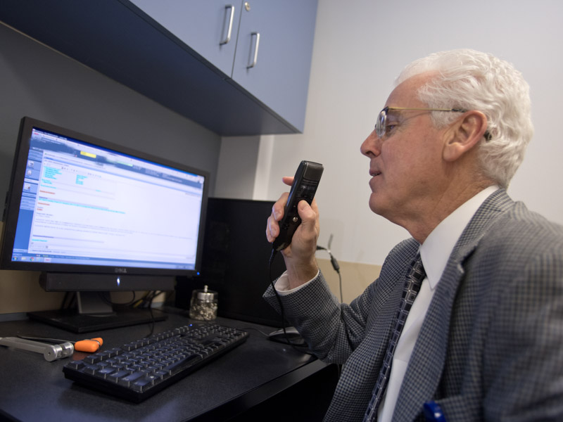 Dr. Louis Harkey records notes from a patient encounter in 2016. Administrative duties were among his favorite responsibilities during his lengthy UMMC career.