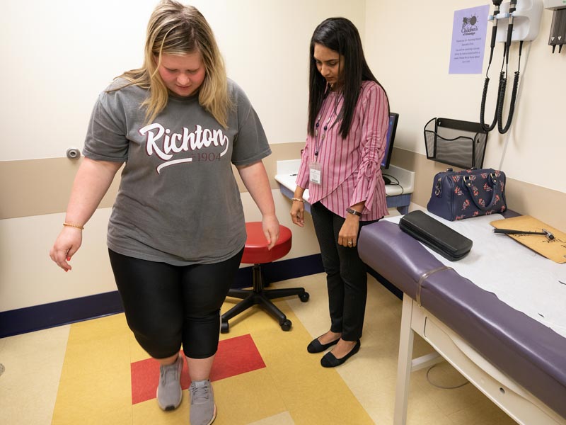 Kalli Dykes of Richton shows her balance to Dr. Riddhiben Patel during an exam at the Children's of Mississippi Specialty Clinic.