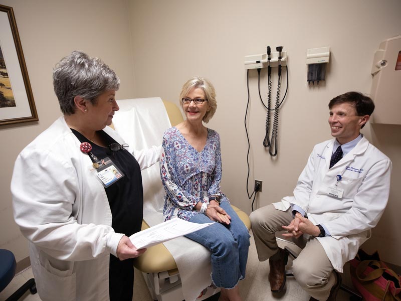 A patient talks to nurse Michele Harrison and her medical oncologist, Dr. lark Henegan.