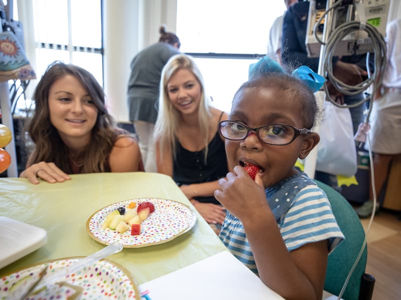 Children's of Mississippi patient Verlesia Mangum of Ridgeland eats a healthy snack during a visit from the PGA TOUR Wives Association.