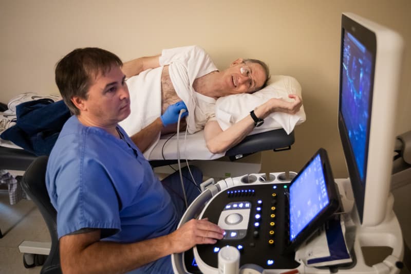 Karol Black, who conducts echocardiograms, works with Fred Robertson, cancer survivor, during a periodic screening at the UMMC Cancer Center and Research Institute.