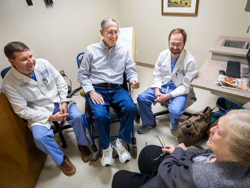 Fred Robertson, second from left, is among the cancer patients Dr. Craig Long, left, and Dr. Brandon Lennep, right, monitor for heart problems. Long and Lennep recentl discussed the results of his most recent screening with Robertson and his wife, Sue.