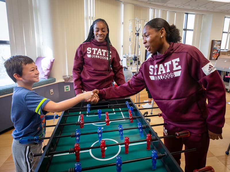 Women’s basketball visits score wins with children’s hospital patients