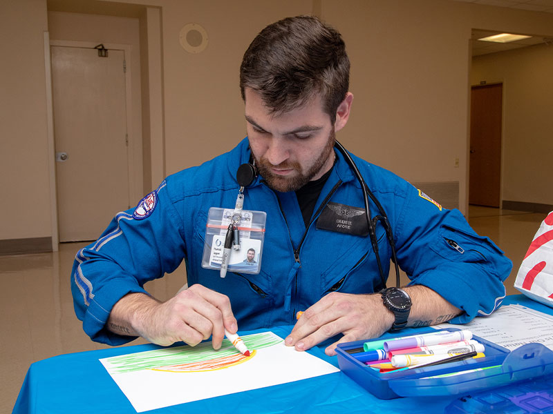 Air Care flight paramedic Cole Logan creates a sunrise that will be one of the thousands of drawings in the mural that will be on display in the lobby of the Children's of Mississippi expansion.
