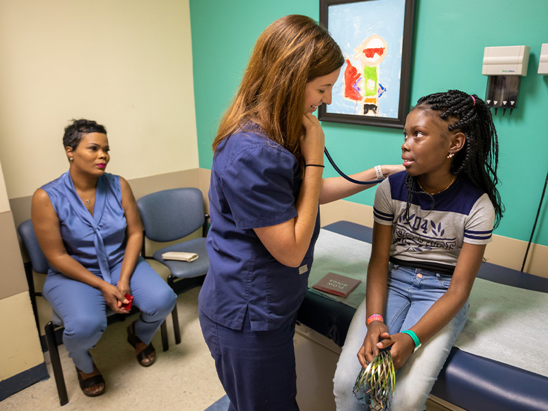 Sarah Elizabeth Elkin, nurse practitioner, checks Kali Mitchell's heartbeat as Mitchell's mother, Joneaset Mitchell, looks on.