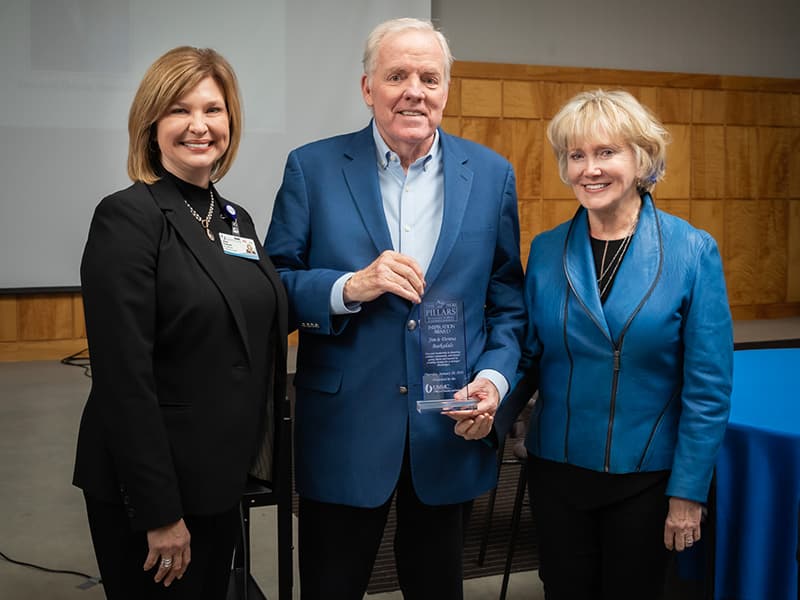 Dr. LouAnn Woodward, left, vice chancellor for health affairs, presented the Pillars Inspiration Award to Jim and Donna Barksdale.