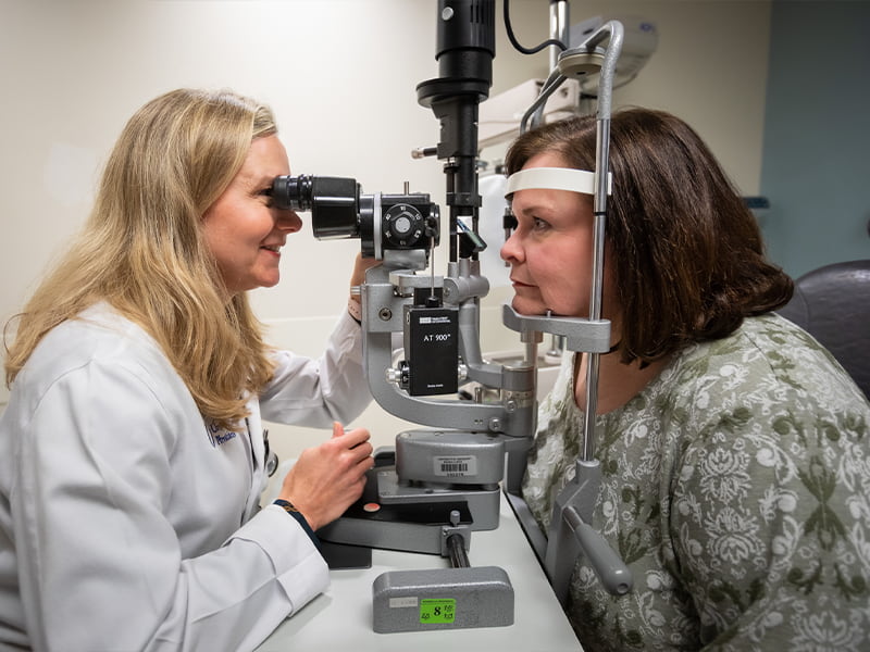 Ophthalmologist gives female patient eye exam.