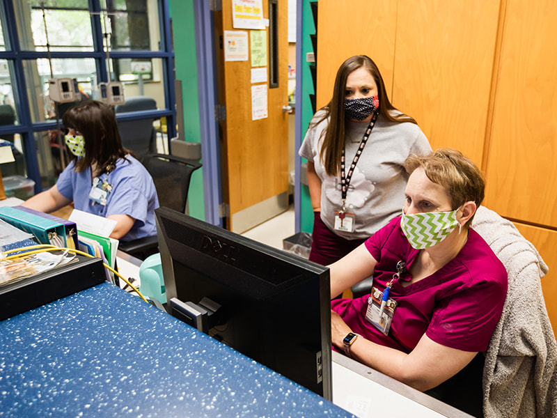 Wearing masks while working to prevent the spread of COVID-19 are, from left, Hannah Alfonso, nurse; Jennifer Smith, social worker; and Tammy Roberts, nurse.