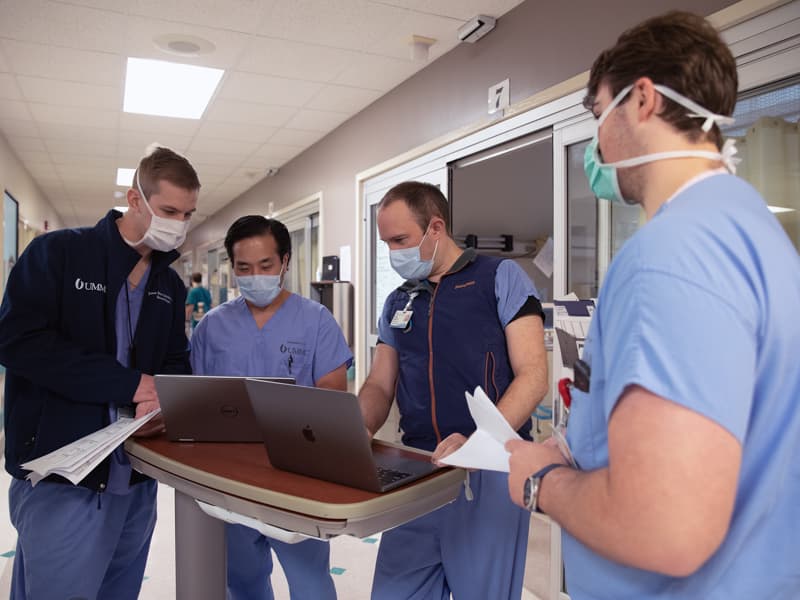 Dr. Matt Kutcher, second from right, during rounding in the UMMC SICU. Kutcher is coauthor on a study about appendicitis treatment options that was published in New England Journal of Medicine. With Kutcher, from left, are Dr. James Littlejohn, Dr. Lam Pham and Brock Richardson.