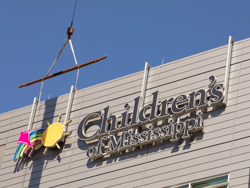 The Children's of Mississippi sign is shown being placed on the Kathy and Joe Sanderson Tower.