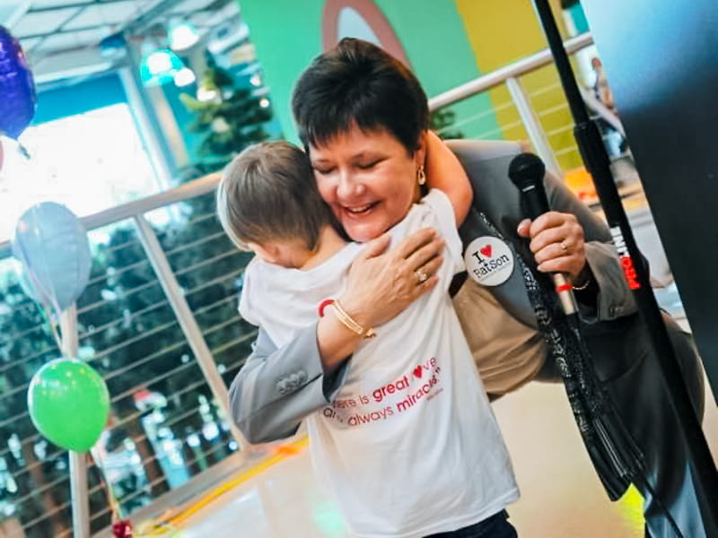 Gillespie hugs UMMC's Children's Miracle Network Champion during a 2000 visit to the Mississippi Children's Museum in Jackson.