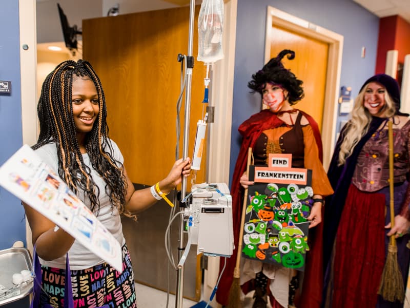 Children's of Mississippi patient Calvionne Fox of Hattiesburg plays a Halloween costume scavenger hunt game Friday with hospital staff including nurse practitioners Amy Lowery Carroll, center, and Amanda Hodges.
