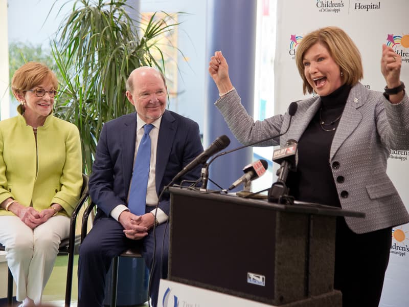 Dr. LouAnn Woodward, vice chancellor for health affairs and dean of the School of Medicine, cheers at the announcement of a $10 million gift toward a pediatric expansion at UMMC from Kathy and Joe Sanderson, left, in this photo from 2016.