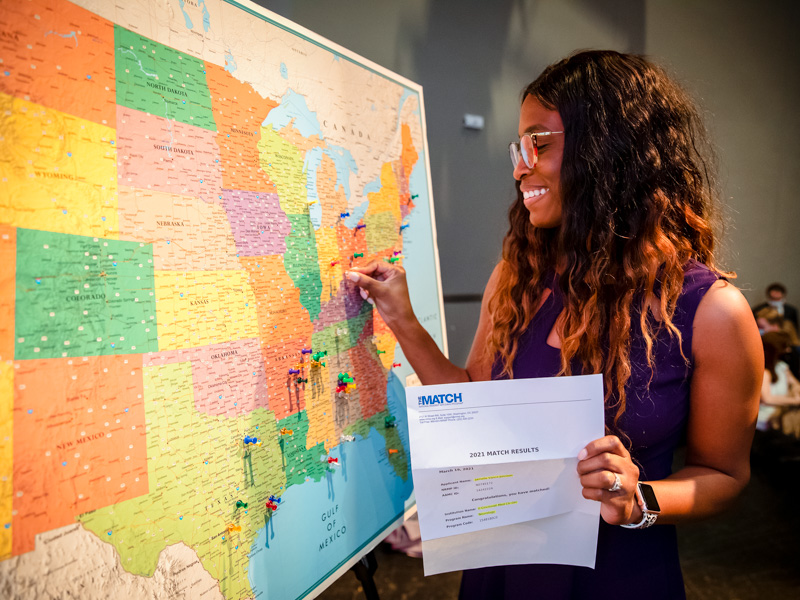 On a United States map displayed on stage at Thalia Mara Hall, Jamelle Johnson sticks a pin in Cincinnati, Ohio, where she matched for her residency in neurology.