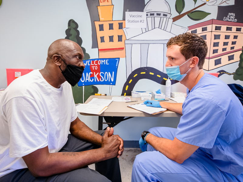 Sherrod Brothers of Jackson answers questions from Samuel Hopper, first-year medical student, before receiving the Johnson & Johnson COVID-19 vaccine April 10 at the Jackson Free Clinic.