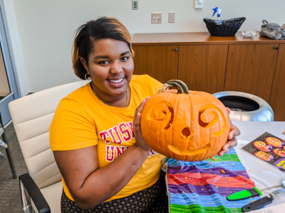 Whalen shows off her carving skills for her department's Halloween celebration.