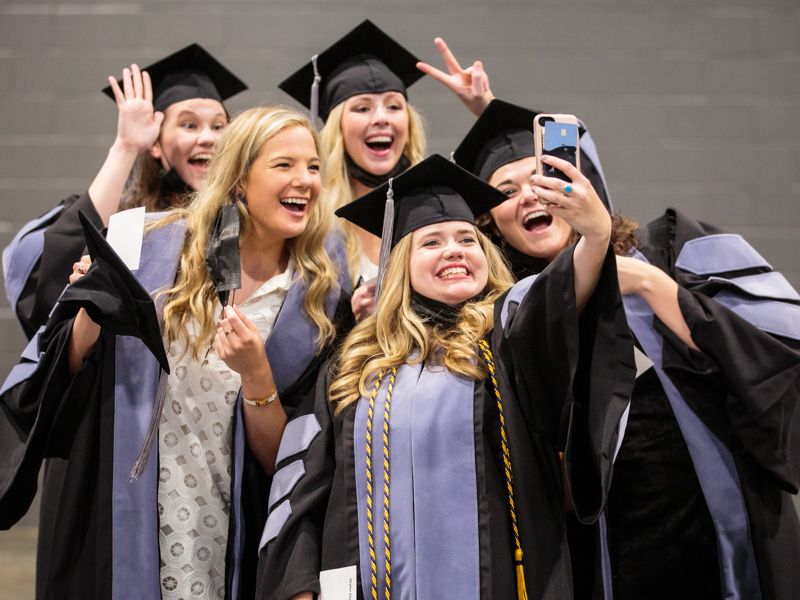 Graduates pose for a selfie.