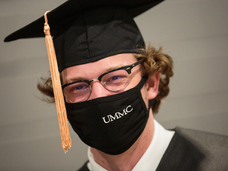 Bachelor of Science in Nursing candidate Caleb Harrison smiles behind his face mask during commencement for the School of Nursing.