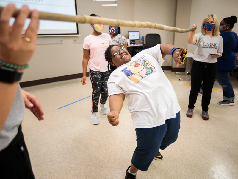 Iron Kid Danayia Cox of Jackson does the limbo during a class session at UMMC's Center for Integrative Health in Ridgeland.