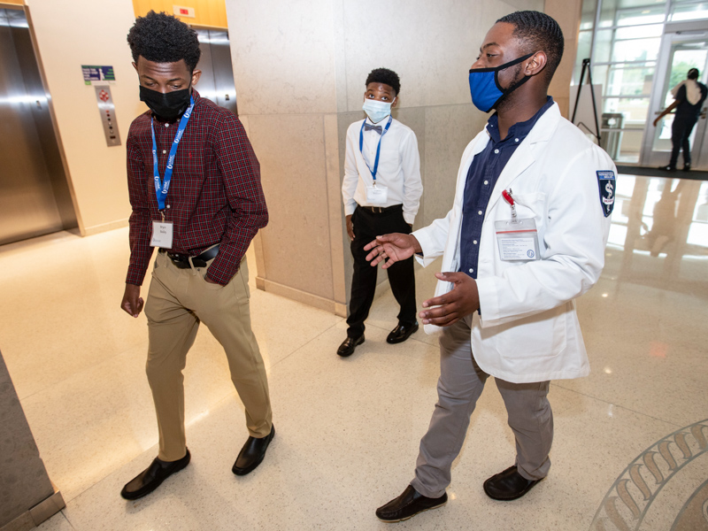Black Men in Healthcare Empowerment Summit co-organizer Akeelein Forrest, a second year School of Medicine student at UMMC, talks with Bryce Bailey, left and Bryston Williams during the summit June 26, 2021.