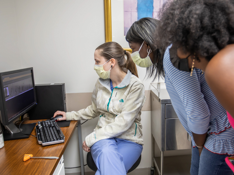 Dr. Allison Strickland shows Felicia Beasley, center, a scan of her aneurysm during a follow-up appointment after Beasley's trans radial web surgery. Looking on is Beasley's daughter, Melicia Beasley.