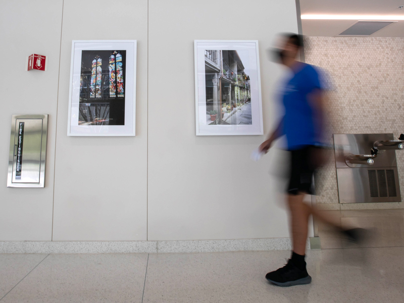 First-year medical student Isaac Spears passes by images from the “Color Our Walls” student photography exhibit in the School of Medicine.