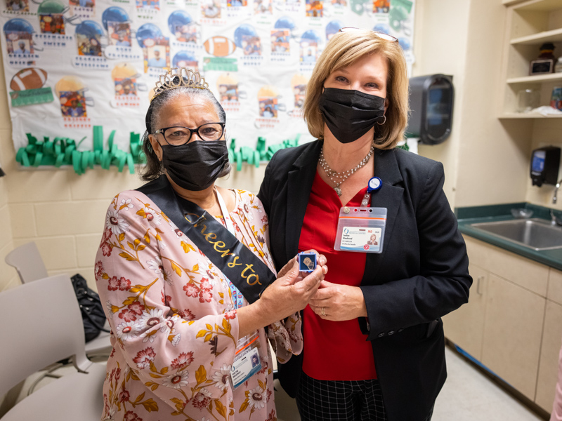 On the day of her 50th work anniversary, Verlyne Broadway is visited by Dr. LouAnn Woodward, who congratulated her with only the second-ever awarding of a 50-year pin.