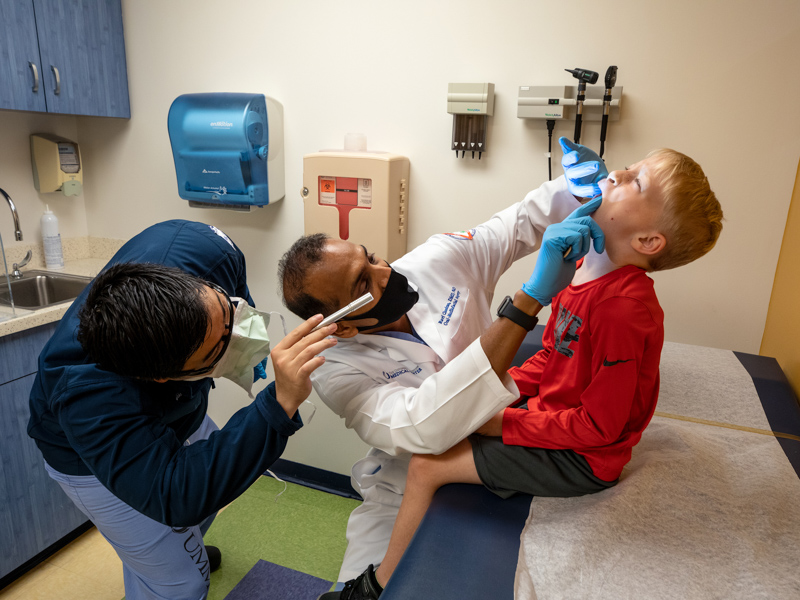 From left, oral-maxillofacial surgery resident Dr. Mark Lim and Dr. Ravi Chandran, chair of oral-maxillofacial surgery in the School of Dentistry at UMMC, check patient Cooper Beall during his visit to Children's of Mississippi's multidisciplinary cleft clinic.