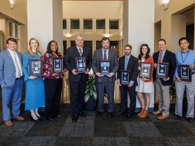 Silver award recipients, from second left to right, Dr. Lais Berro, Dr. Tearsanne Davis, Dr. Alexandre da Silva, Dr. Scott Williamson, Dr. Andrew Voluse, Dr. Angela Duck, Dr. Joshua Mann and Dr. Hao Mei. At left is Dr. Gene Bidwell. Not pictured is Dr. Thomas Dobbs.