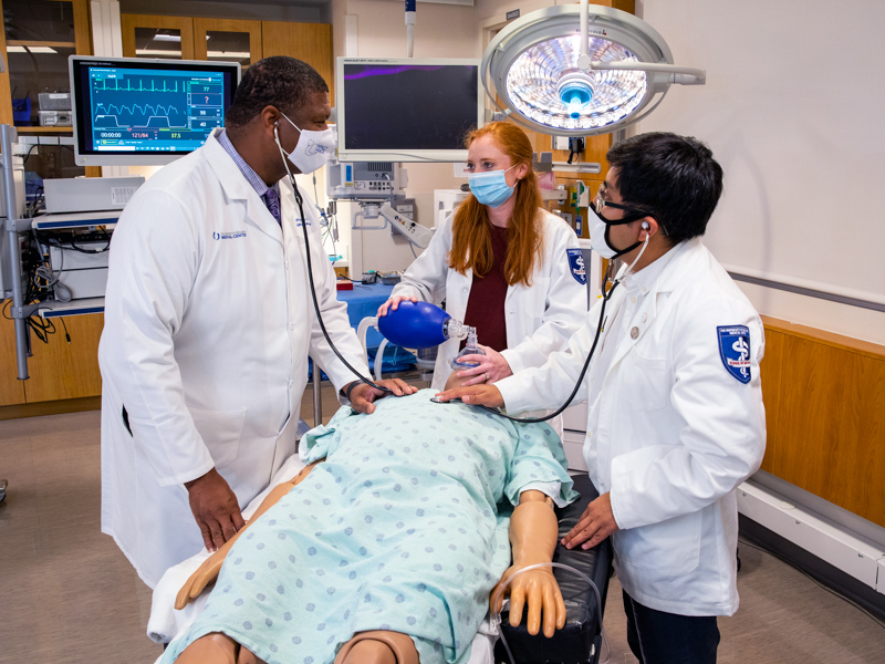 Using a medical manikin, Dr. Demondes Haynes, left, discusses some finer points of patient care with, from left, medical students Frances Lancaster and Donaldo Martinez in the School of Medicine Simulation Lab.