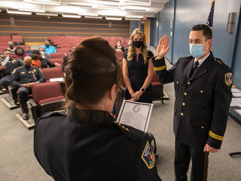 Chief of Police and Executive Director of Public Safety Mary Eileen Paradis swears in Deputy Chief of Police Joshua Bromen as his wife, Paige Bromen, looks during the UMMC Police Department fall ceremony.