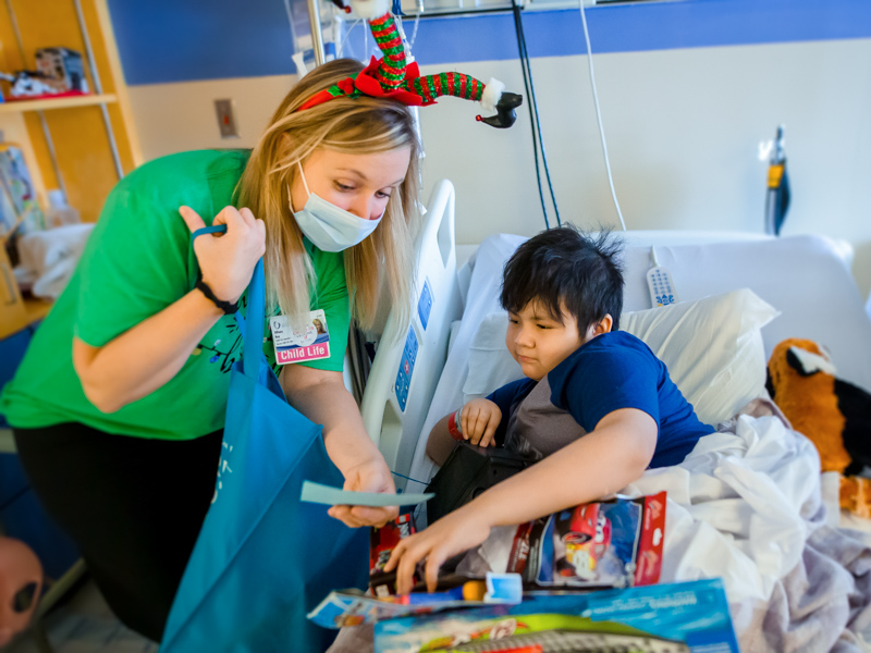 Child life specialist Tiffany Key brings Christmas gifts to Children's of Mississippi patient Angel Martinez of Forest in a 2020 file photo.