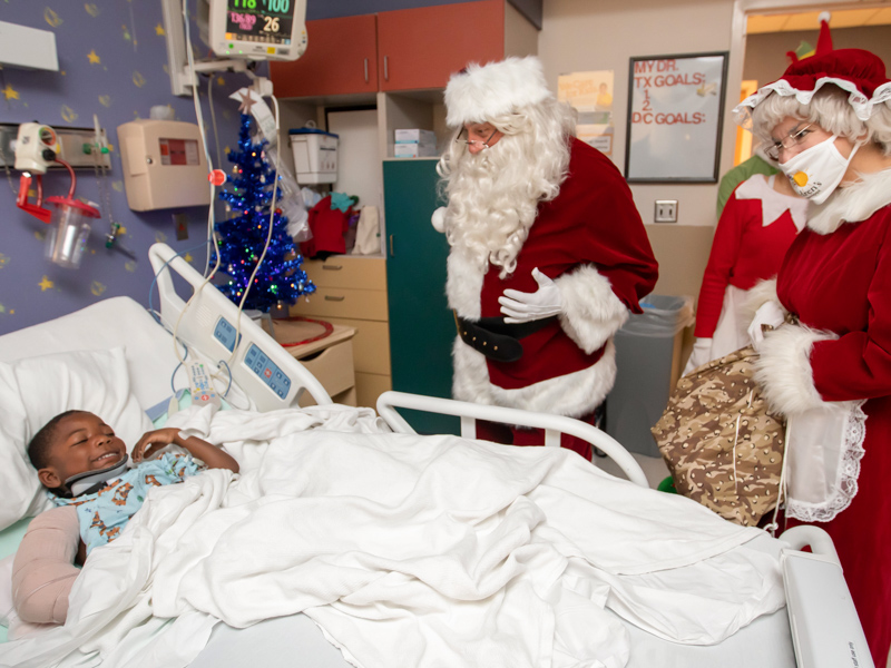 Children’s of Mississippi patient Braxtyn Johnson gets a visit from Santa and Mrs. Claus during their inpatient visit at Blair E.Batson Tower Wednesday.