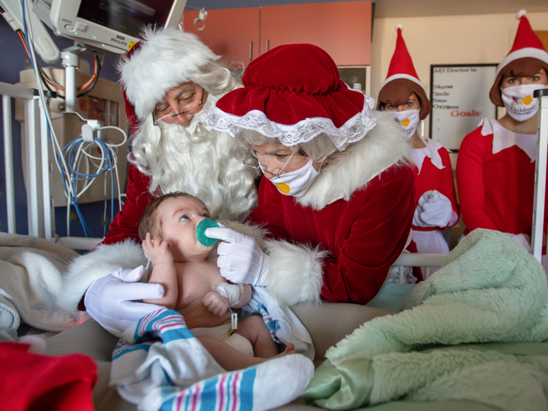 Two-month-old Henry Carpenter gets a visit from Santa and Mrs. Claus and their elves during an inpatient visit at Children's of Mississippi Wednesday.