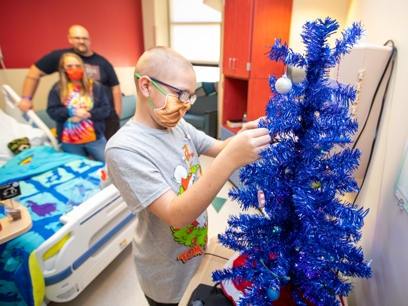 Children's of Mississippi patient Ryder Jackson of Long Beach decorates a Christmas tree in his hospital room alongside his mother, Marie Paquin, and father, Nicone Paquin, following a visit to BankPlus Presents Winter Wonderland.