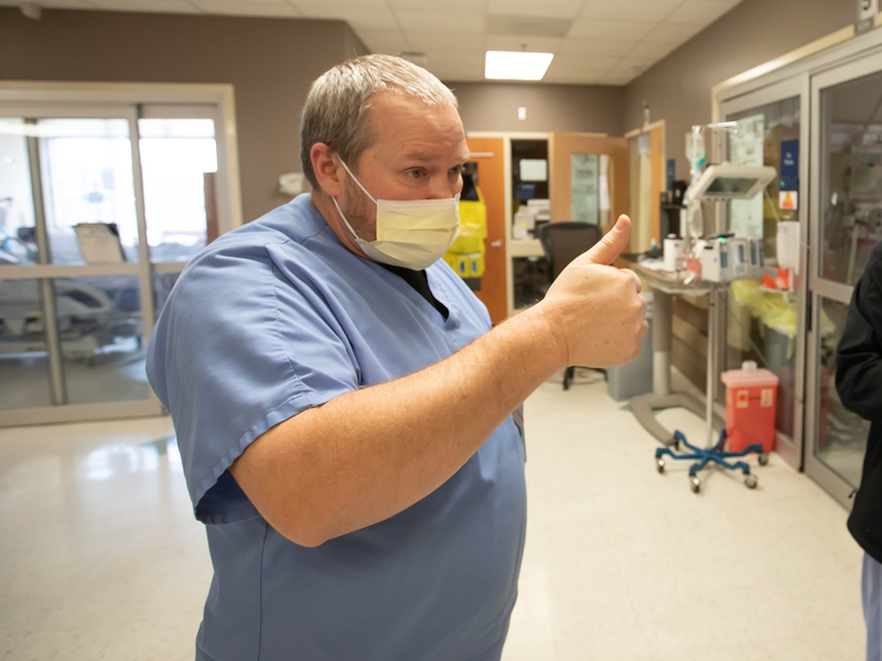 John Brinson, a respiratory therapist and interim manager of respiratory therapy care, gives a thumbs up to explain how nurses and therapists communicate in and outside of COVID-19 patient rooms when prepping for ventilator next steps.